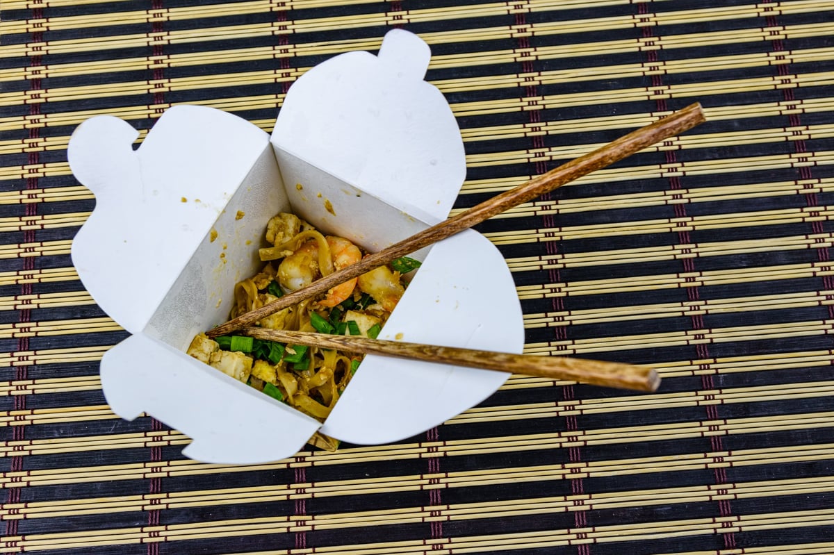 Pad thai in paper box with chopsticks